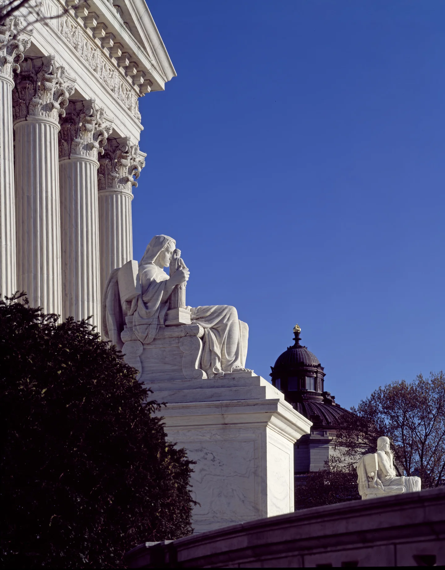 A seated marble figure beside the Supreme Court's steps.