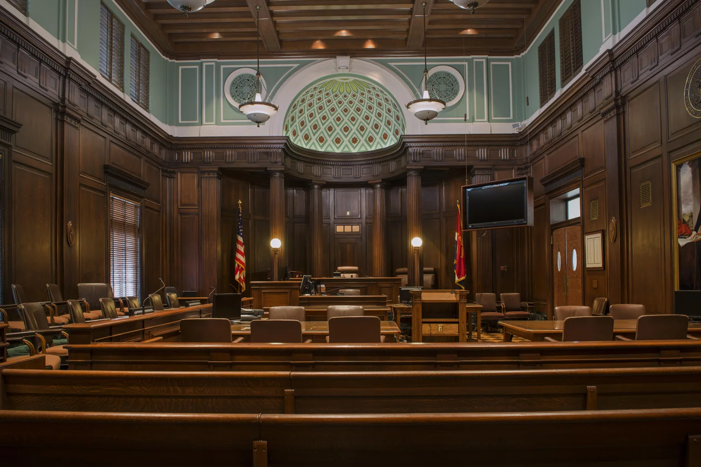 A wood-panelled federal courtroom with a carved canopy above the bench.