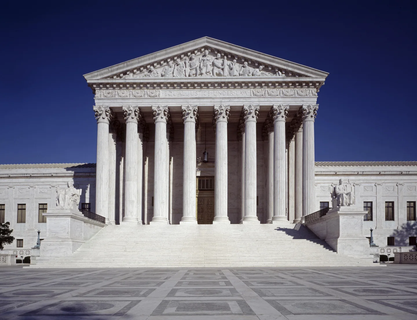 The marble front of the Supreme Court under a deep blue sky.